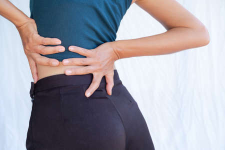 Close up woman grab the waist with pain bone.slim fit and Authentic skin tan asian Thailand. health kindey problems because drink less water or Pain from sitting for long periods of time and hard workの写真素材