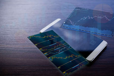 Image trade forex graph stock market on mobile of smartphone with wooden table background....