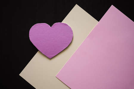 Pink paper heart chape on yellow and pink paper with black background. romantic and love valentines day concept. flat lay with copy space.の写真素材