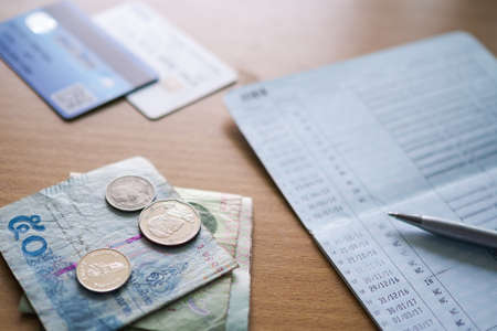 Bank note and coin with creditcard and bank book on wooden table. Business and financial for plan money saving 2021 year, stock market concept.の写真素材