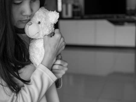 Asian woman hug deddy bear with loneliness. black and white image. broken heart concept.の写真素材