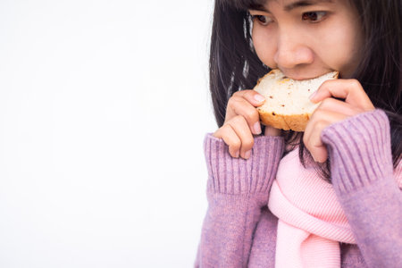Asian woman with guernsey  eating raisin bread starving and delicious in winter. Breakfast or snack...
