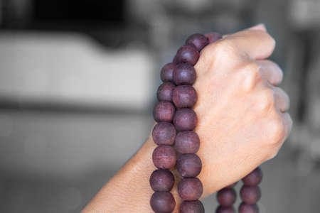 Hand woman holding rosary on blur backgrond. female christian catholic religious faith praying.