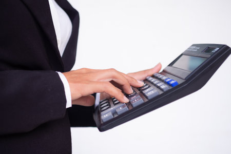 Cropped hand business woman with black suit holding caculator on white background.  business or finance concept.の写真素材