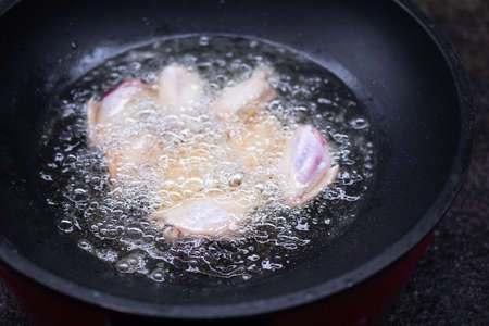 Fried wings chicken with vegetable oil in black pan. fry cooking thailand. fast food and foods that increase obesity, fat concept.の写真素材