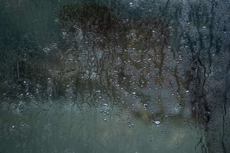 Drop water on glass window in rain day . card or poster symbols for sad, lonely, divorce couple,...