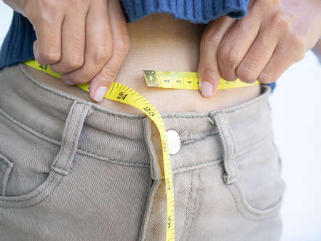Waist woman with tape measure. body shape slim fit young girl. authentic skin tan. shapely, diet,...