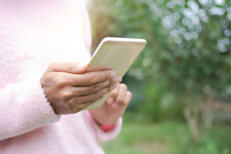 Woman with sweater use touchscreen mobile smartphone. she chat to friend send message and shopping...