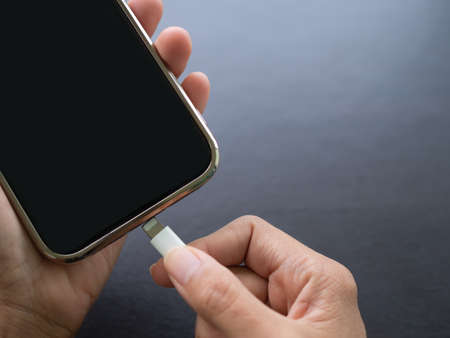 Finger holding cable USB type C for charge battery mobile smartphone. Technology for lifestyles and business concept.の写真素材