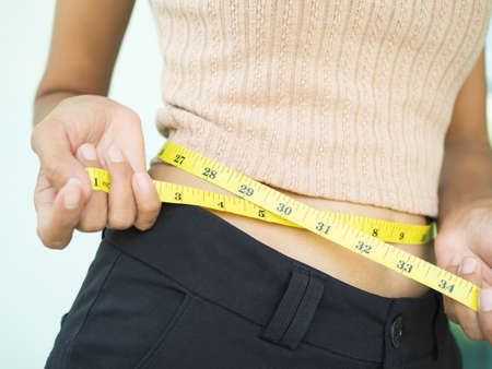 Waist woman with tape measure. body shape slim fit young girl. authentic skin tan. shapely, diet,...