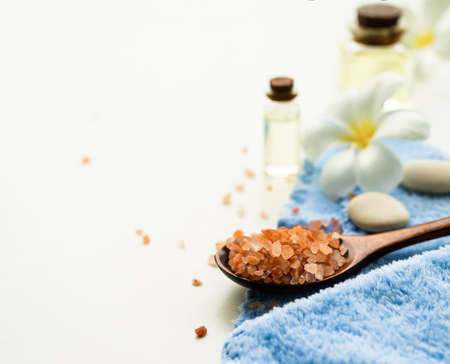 Himalayan Salt Spa in wooden spoon with Massage Oil,Zen pebble,frangipani flowers,Towel on white background.essential medicine natural oriental treatment  Aroma therapy Spa set. bath for healthy.の写真素材