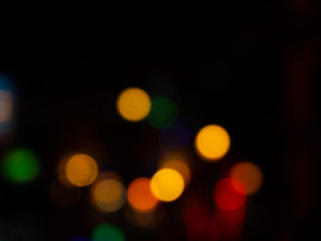 Light Night Bokeh dark Black Background,Abstract Orange Red Colorful Circle Effect Sparkle Blurry Backdrop,for Invitation Special Gala,Birthday Card,Christmas Holidays Celebration,Happy New Year 2023.の写真素材