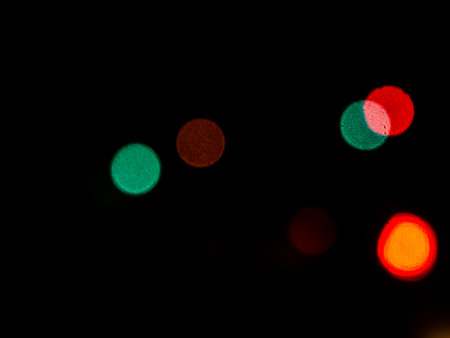 Light Night Bokeh dark Black Background,Abstract Orange Red Colorful Circle Effect Sparkle Blurry Backdrop,for Invitation Special Gala,Birthday Card,Christmas Holidays Celebration,Happy New Year 2023.の写真素材