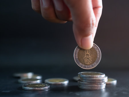 Stack coin,Closeup Finger Woman holding Money with blur Pile Cash on Blue Background,Bank Currency Thai,Plan Income Investment Growth and Saving for 2023 New Year,Business or Treasury Finance Concept.の写真素材