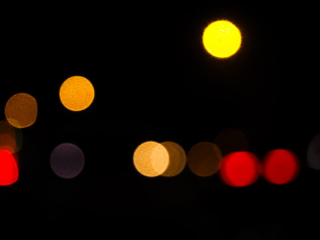 Light Night Bokeh dark Black Background,Abstract Orange Red Colorful Circle Effect Sparkle Blurry Backdrop,for Invitation Special Gala,Birthday Card,Christmas Holidays Celebration,Happy New Year 2023.の写真素材