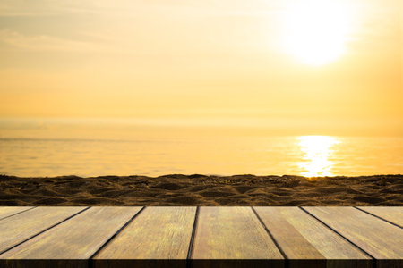 Empty Wooden Table on blur Sea with Sunset Background,Blank Counter on Water Ocean with sunrise at Coast,Mock Up Shore Seaside Island Nature Landscape Backdrop,Broken Heart or Tropical Summer Holidaysの写真素材