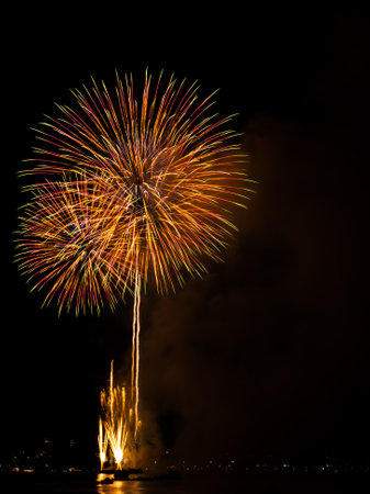 Firework on Black Dark Sky Background,Celebrate Party Merry Christmas and Happy New Year Festival,Light Bright Bokeh Gold Abstract Burst Fire Anniversary Birthday Holidays Wallpaper,Colorful Night.の写真素材