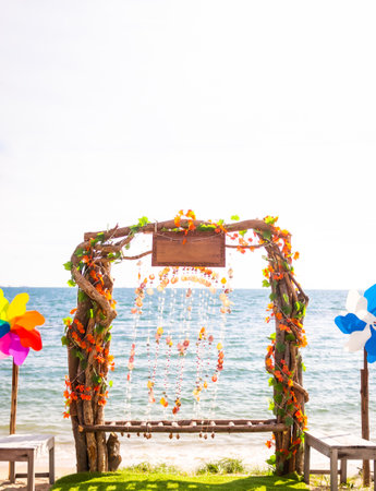 wedding arch on sand beach at coast blur blue sea background. tourism for tropical travel summer holidays concept.の写真素材