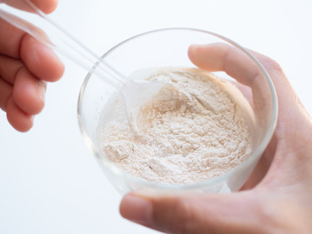 Banan Raw Powder,Banana Flour on Spoon with Water in Glass,Finger Make Flour Banana in Glass on white Background,Traditional Herb in Asian Thailand,Vegetable Food  nature for Diet and Treat Gastritis.の写真素材
