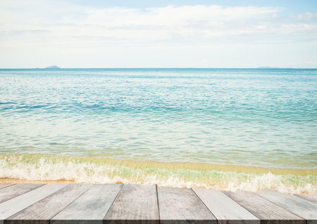 Table on Blue Sea and Cloud White Background,Tropical Summer Nature,Splash Surf Water Ocean Wave on Wooden Floor at Coast for Tourism Vacation Travel Holidays of Resort,Beautiful Islan Bay space.の写真素材