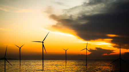 Wind Mill Farm Offshore Sea on Sunset,Energy Power Electric Plant on Water Nature Sky Lanscape,Technology Turbine Windmill Sustainable Industry,Electric Business for Environment Conservetion Concept.の写真素材