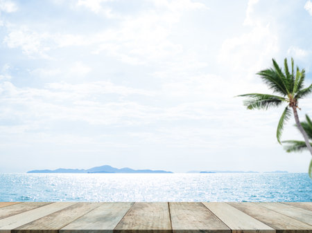 Table on Sea and Blue Sky Background,Deck Product Summer Cosmetic,Wood on Water Ocean at Coast wit Palm Tree,Board Tropical Nature Space,Tabletop on View Nature Shore,for Tourism Travel Holidays.の写真素材