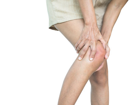 Woman suffering from knee pain on white background. Health care and medical concept.の写真素材