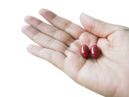 Astaxanthin Supplement Capsule on palm up Woman Isolate on White Background and Clipping Path,Vitamin Food Pill Nutrition Medicine for Good Health,Antioxidant Natural Medical Mineral Pharmacy Herbal.の写真素材