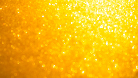 Bokeh Gold Glister Light Abstract Background, Dark Dust Christmas Shine Yellow Party Effect Sparkle Glow Magic Texture blur Flare Bubble Orange Color Card Party Celebrate Happy New Year Xmas Luxury.の写真素材