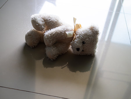 Teddy Bear on Floor Shadow Window Home Sign for Broken Heart Child Beaten Sad Lonely Depressed.の写真素材