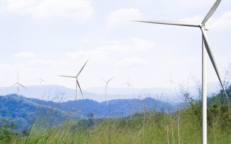 Wind Mill Power Energy Farm Generator Renewable Sustainable Field on Green Lnadscape Mountain, Environment Eco System Technology Industry Ecology Electricity Power Propeller Turbine Clean Carbon.の写真素材