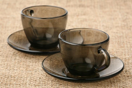 Two coffee pairs of dark glass against a sacking の写真素材