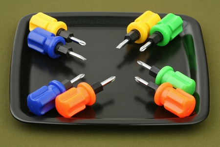 Eight screw-drivers with multi-coloured handles on a tray の写真素材