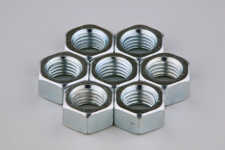 Seven metal nuts on a grey background の写真素材