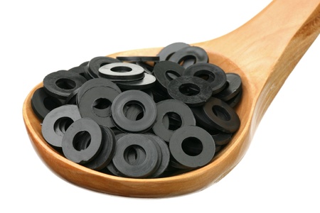 Gaskets in a wooden spoon on a white background 