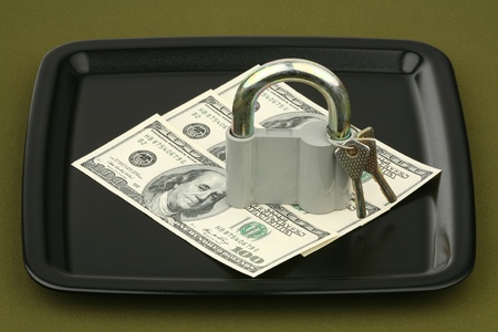 Dollars under the lock on a ceramic tray の写真素材