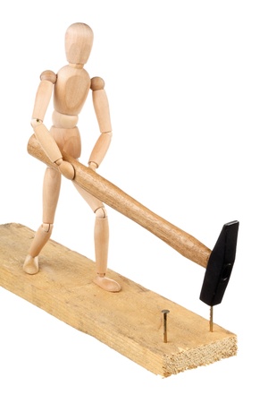 The wooden dummy with a hammer to drive nails into a board isolated on white backgroundの写真素材