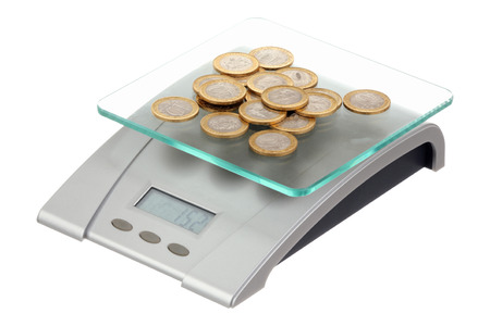 Coins on electronic scales isolated over white backgroundの写真素材