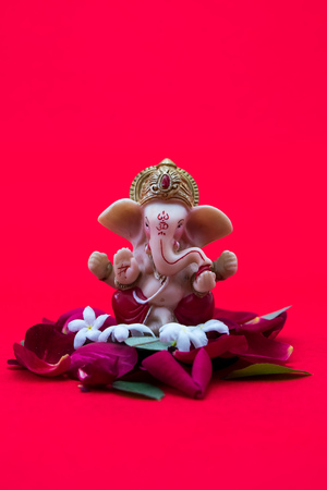 Lord Ganesha Idol with rose petals on red background, ganesh chautrhi, ganesh poojaの写真素材