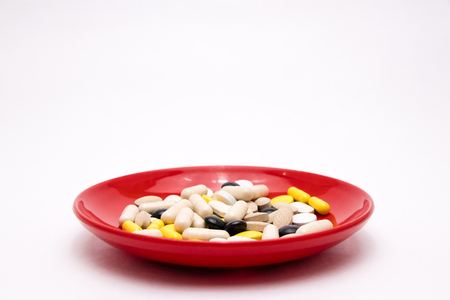 Pharmacy theme Multicolored Isolated Pills and Capsules on plateの写真素材