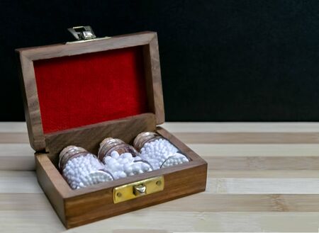 Glass Bottles of homeopathic pills in old opened wooden box on dark background - classic Homeopathy conceptの写真素材