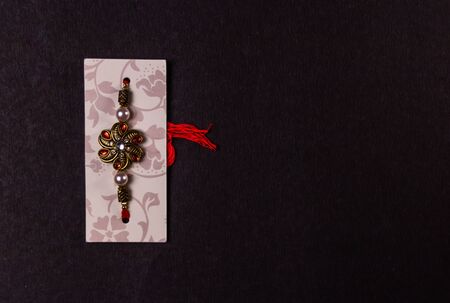 Raksha Bandhan festival Concept - Designer Rakhi or Wrist Band isolated on black background. Rakhi - Symbol of love between Brothers and Sistersの写真素材
