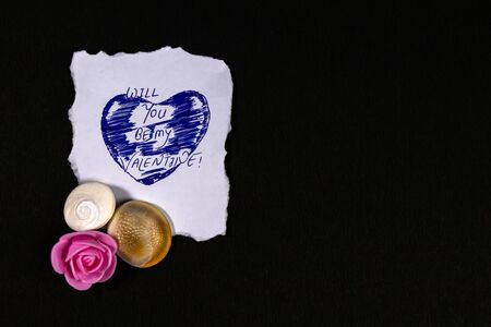 Message quote on white paper with artifical rose flower and seashell on black backgroundの写真素材
