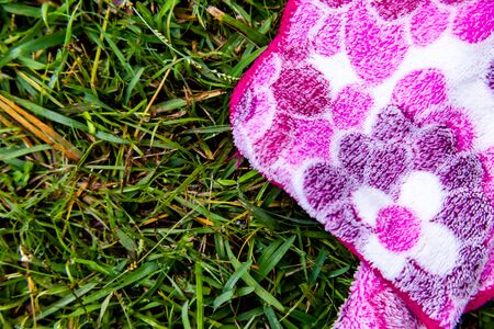 close up of handkerchief laying on green grass with copy space. garden and picnic concept