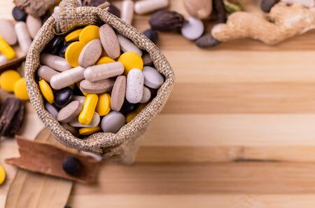 Top view of ayurvedic medicine in a jute sack with assorted  Spices and dry herbs on wooden background. Medicine conceptの写真素材