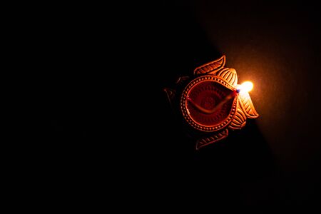 top view of amazing earthen lamp glowing over the black background with copy space in left. faith conceptの写真素材