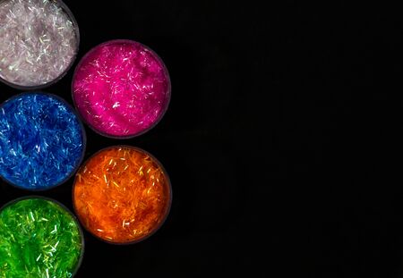 top shot of beautiful colorful rangoli in bowls on black background with copy space. diwali concept