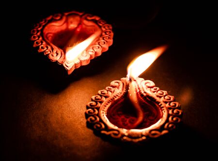 beautiful two terracotta lamps glowing on black background. religious and belief conceptの写真素材
