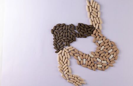 Top view of Liver and Stomach shape made with Herbal tablets on a white background with copy space....