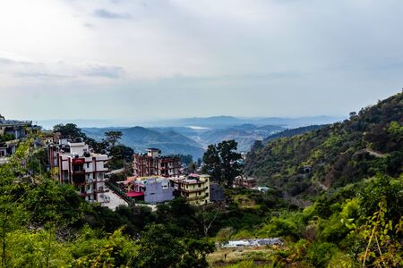 high angle shot of buildings situated on mountains and cloudy sky in the bacgroundの写真素材